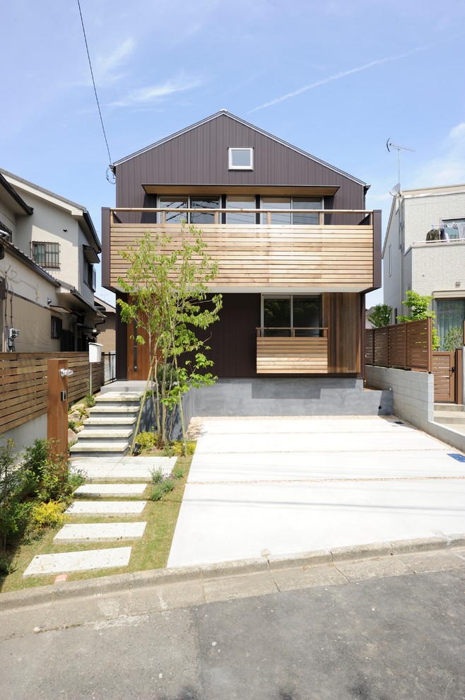 Foto på ett minimalistiskt brunt hus, med två våningar, sadeltak och tak i metall