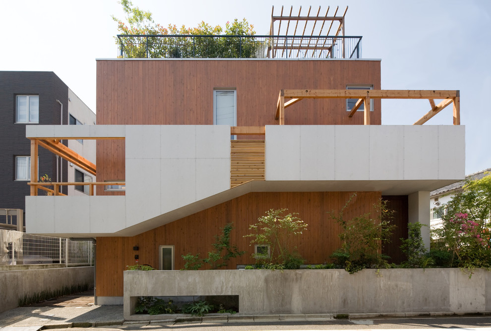 Zweistöckiges Asiatisches Haus mit brauner Fassadenfarbe und Flachdach in Tokio