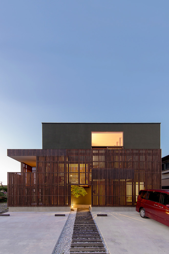 На фото: двухэтажный, серый частный загородный дом в восточном стиле с комбинированной облицовкой и плоской крышей