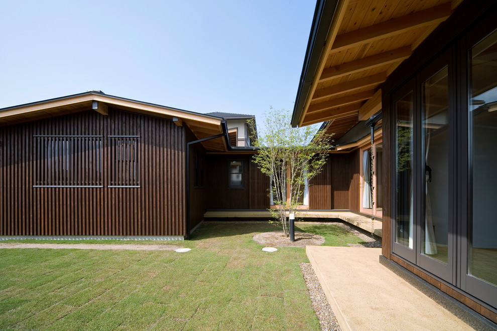This is an example of a medium sized and brown scandi bungalow detached house in Other with wood cladding, a metal roof and a pitched roof.