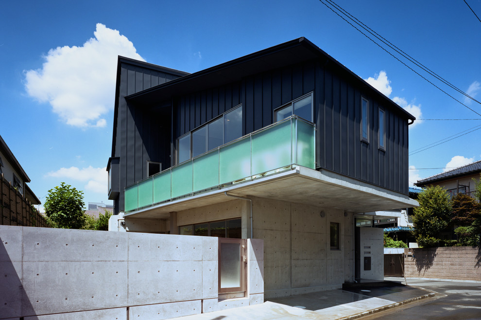 Exemple d'une façade de maison noire moderne en béton de taille moyenne et à deux étages et plus avec un toit en appentis et un toit en métal.