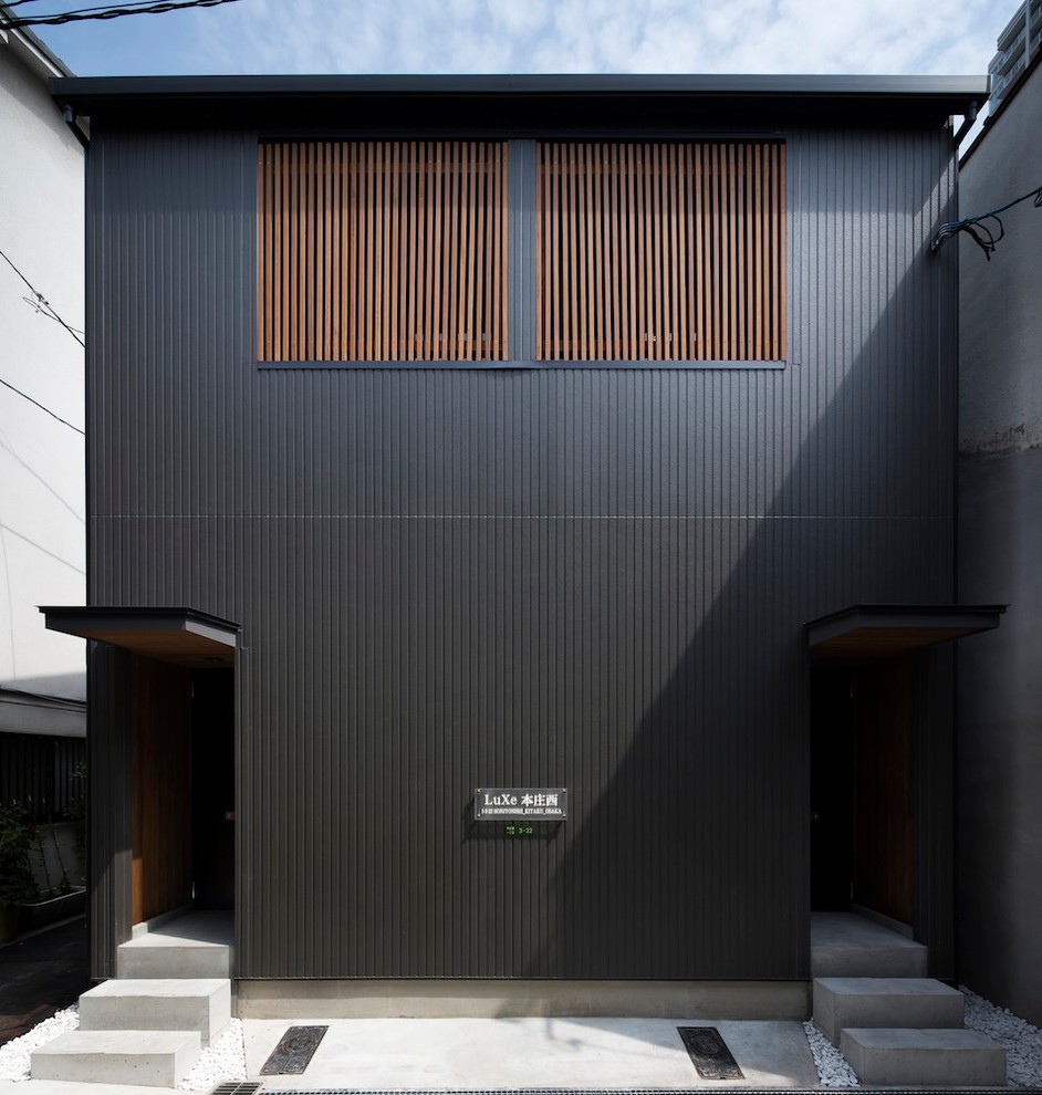 Kleines, Zweistöckiges Asiatisches Wohnung mit Faserzement-Fassade, schwarzer Fassadenfarbe, Satteldach und Ziegeldach in Osaka