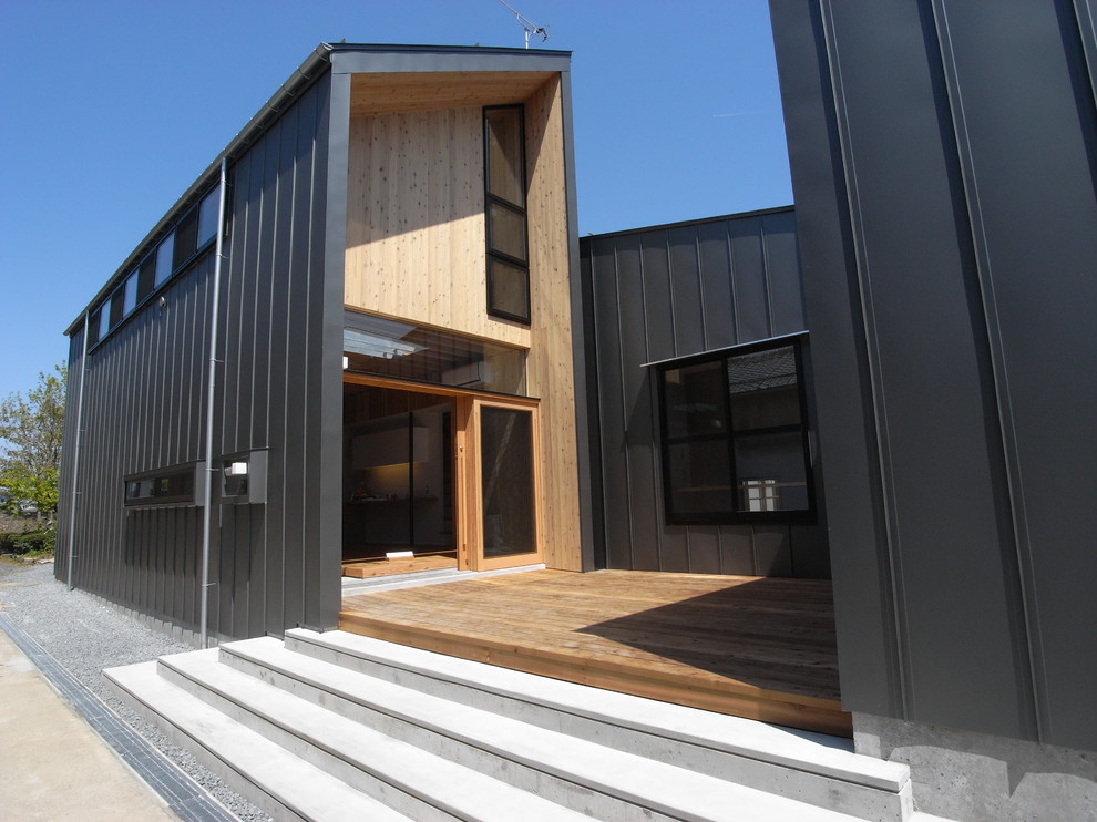 Idee per la facciata di una casa grande nera industriale a due piani con rivestimento in legno e tetto a capanna