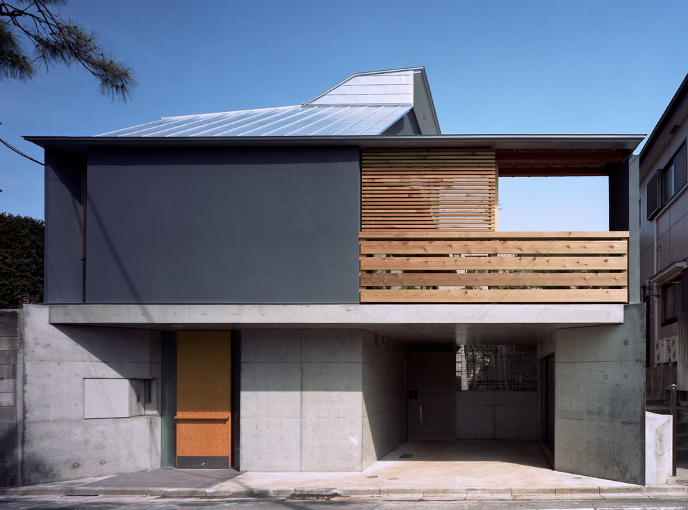 Cette image montre une façade de maison grise asiatique en béton à un étage et de taille moyenne avec un toit en appentis et un toit en métal.