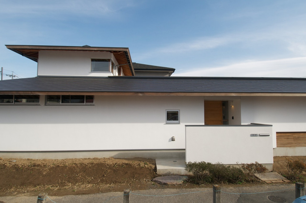 Idéer för att renovera ett mellanstort funkis vitt hus, med två våningar, stuckatur, valmat tak och tak i metall