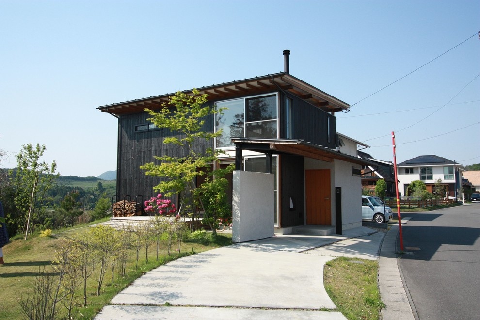Kleines Modernes Haus mit schwarzer Fassadenfarbe und Flachdach in Sonstige