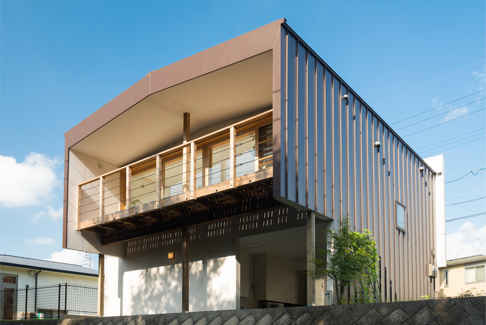 Zweistöckiges Modernes Einfamilienhaus mit Metallfassade, brauner Fassadenfarbe und Satteldach in Sonstige