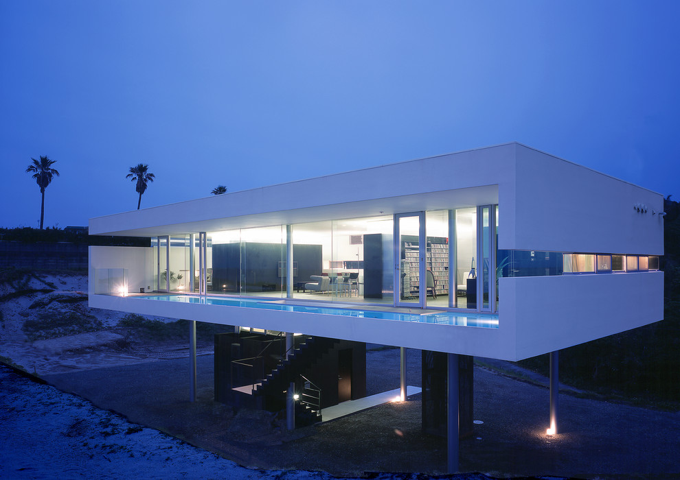 Foto de fachada blanca moderna de dos plantas con revestimiento de vidrio y tejado plano