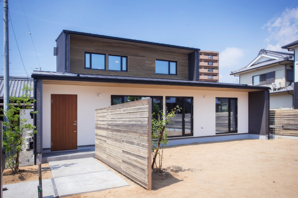 Aménagement d'une grande façade de maison asiatique à un étage avec un toit en appentis et un toit en métal.