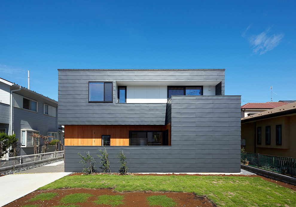 Idée de décoration pour une façade de maison métallique et noire design à un étage avec un toit en appentis et un toit en métal.