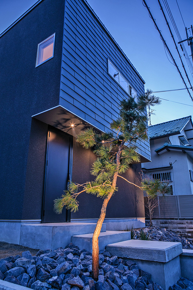 Zweistöckiges Modernes Einfamilienhaus mit Metallfassade, schwarzer Fassadenfarbe, Pultdach und Blechdach in Sonstige