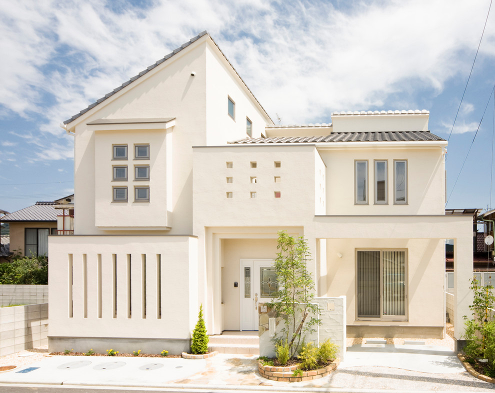 Diseño de fachada de casa blanca contemporánea de dos plantas con revestimiento de hormigón, tejado a dos aguas y tejado de teja de barro