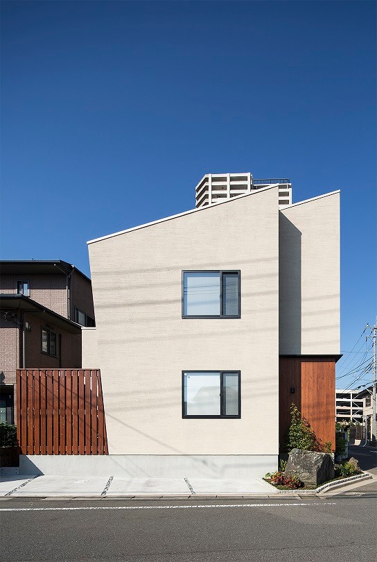Foto della facciata di una casa beige moderna a due piani con copertura in metallo o lamiera