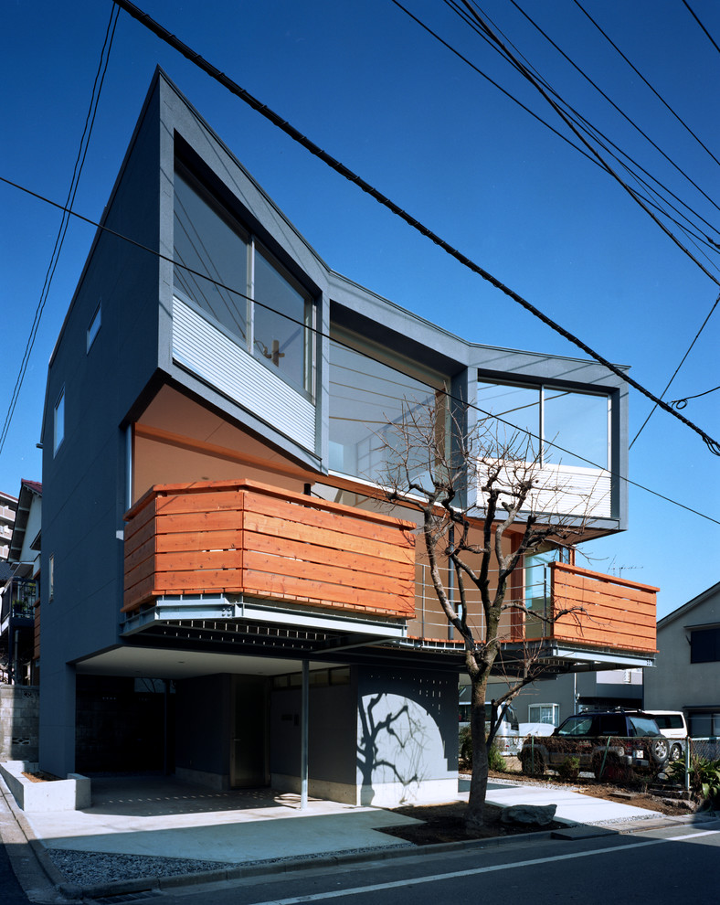 Mittelgroßes, Dreistöckiges Asiatisches Einfamilienhaus mit schwarzer Fassadenfarbe, Flachdach, Putzfassade und Blechdach in Tokio