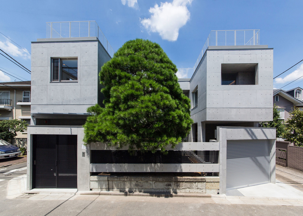 Imagen de fachada gris minimalista con revestimiento de hormigón y tejado plano