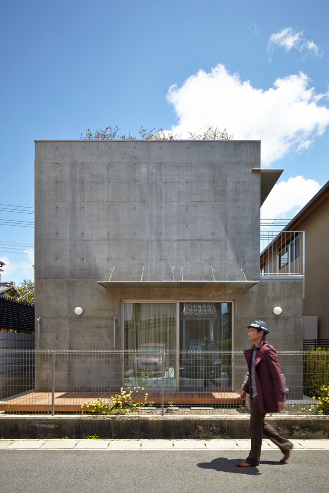 Идея дизайна: двухэтажный, серый дом в современном стиле с облицовкой из бетона и плоской крышей
