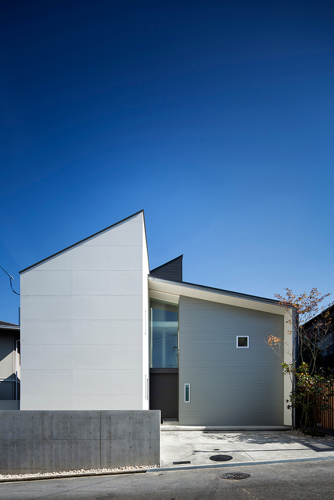 Exemple d'une façade de maison blanche tendance avec un toit en appentis et un revêtement mixte.