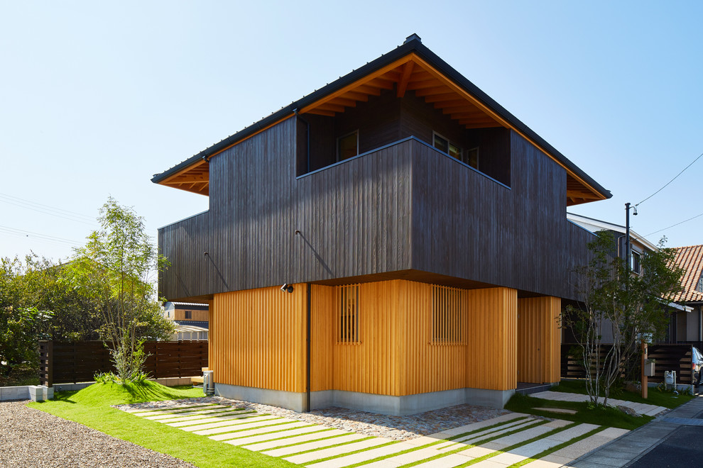 Multi-coloured world-inspired detached house in Other with wood cladding and a pitched roof.