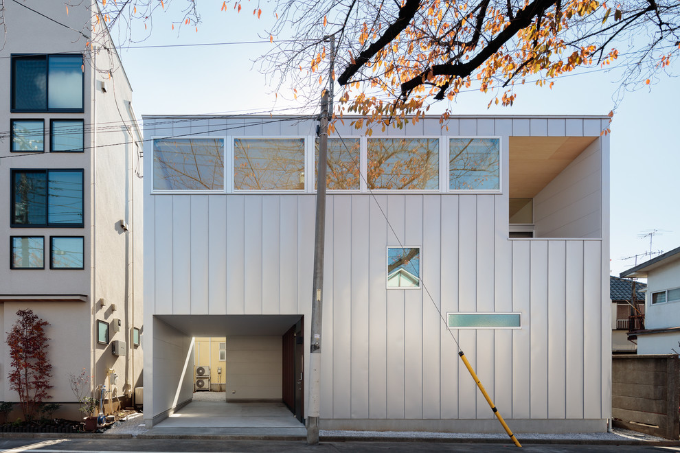 Inspiration pour une façade de maison grise minimaliste avec un toit plat.