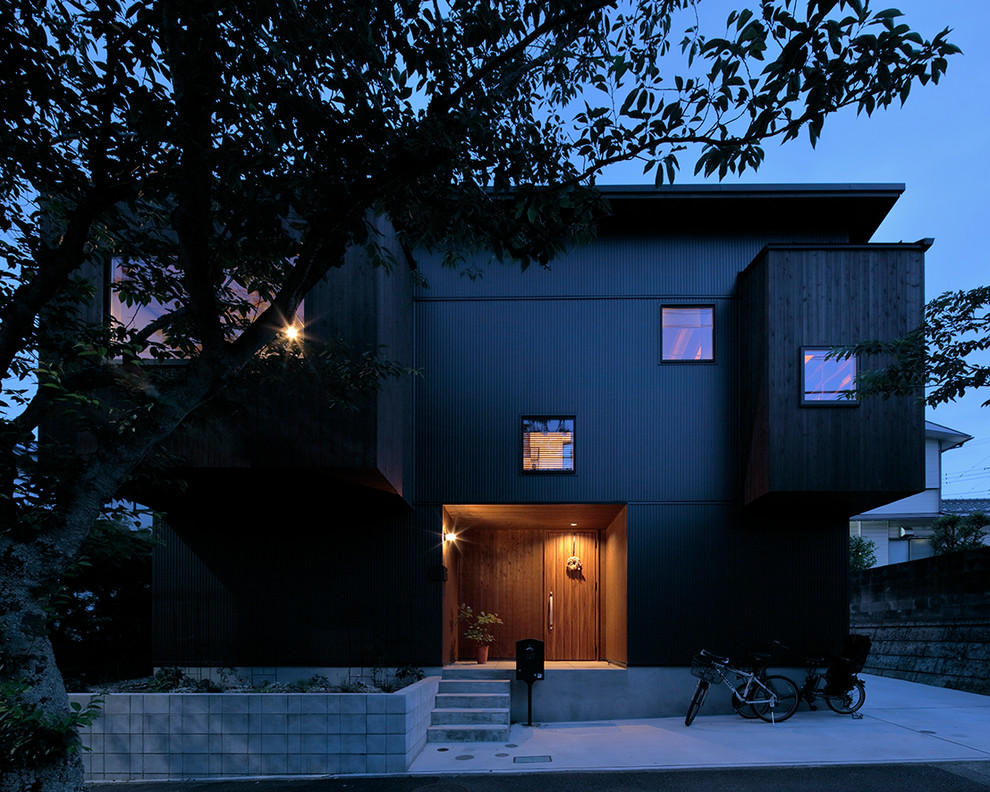 Foto della facciata di una casa marrone contemporanea a due piani di medie dimensioni con rivestimento in legno e copertura in metallo o lamiera