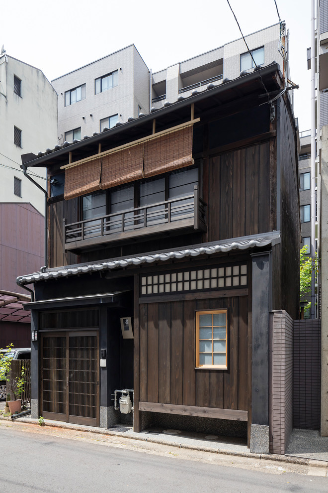 Cette image montre une façade de maison marron asiatique en bois à un étage.