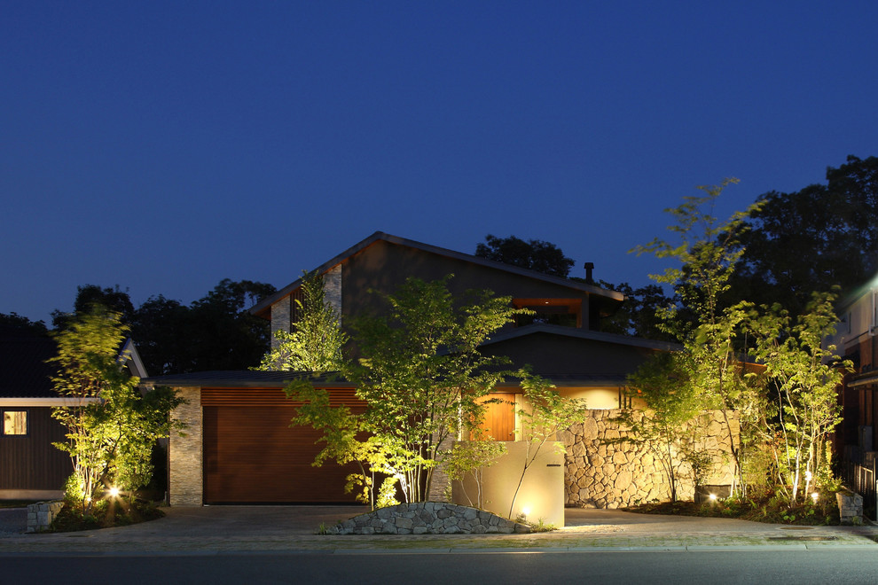 Ejemplo de fachada de casa marrón minimalista grande de dos plantas con revestimiento de piedra, tejado de metal y tejado a dos aguas