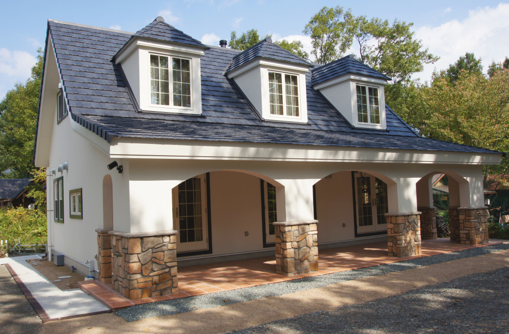 Imagen de fachada de casa blanca de estilo de casa de campo de dos plantas con tejado a dos aguas y tejado de teja de barro