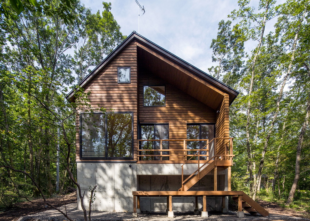 Свежая идея для дизайна: двухэтажный, коричневый дом в стиле рустика с комбинированной облицовкой и двускатной крышей - отличное фото интерьера