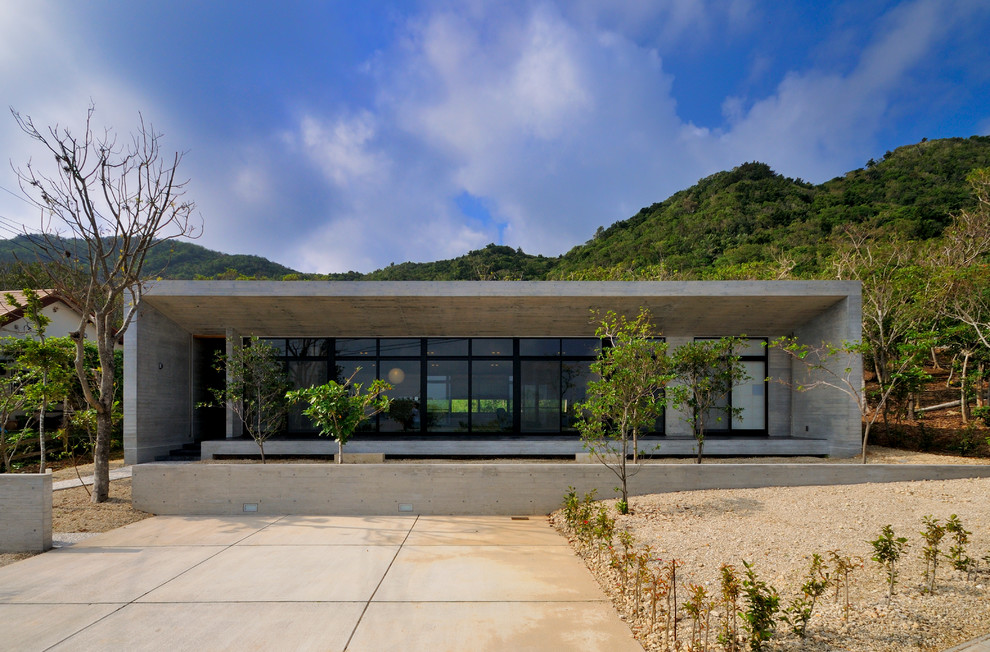 Einstöckiges Modernes Haus mit grauer Fassadenfarbe, Betonfassade und Flachdach in Sonstige