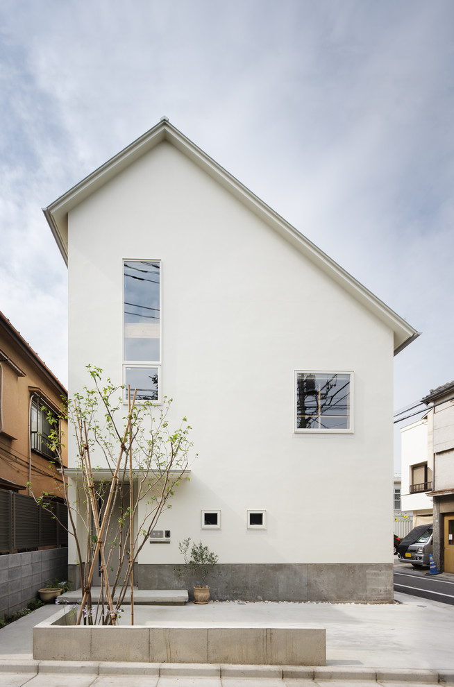 Photo of a white contemporary house exterior in Tokyo with a pitched roof.