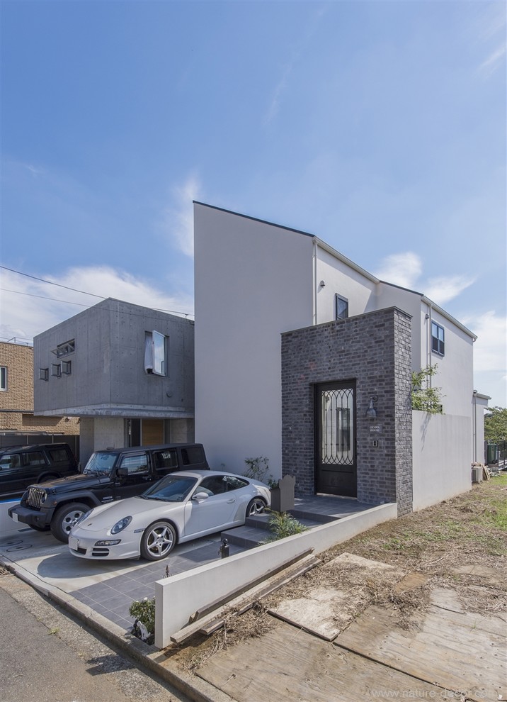 Industrial beige two-story brick exterior home idea in Tokyo with a shed roof