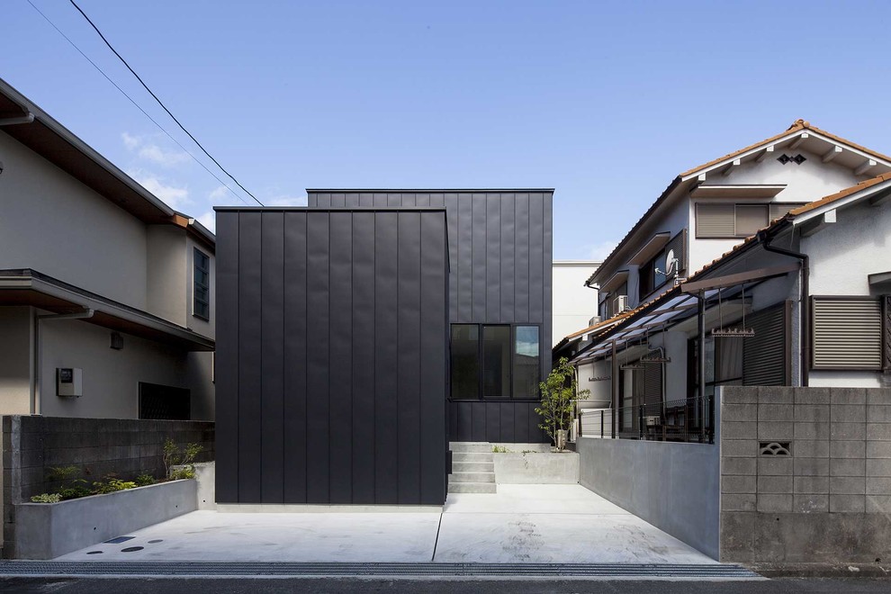 Exemple d'une façade de maison métallique et noire tendance de taille moyenne et à niveaux décalés avec un toit en appentis et un toit en métal.