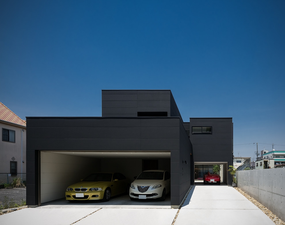 На фото: огромный, двухэтажный, черный частный загородный дом в стиле модернизм с комбинированной облицовкой, плоской крышей, крышей из смешанных материалов и отделкой планкеном