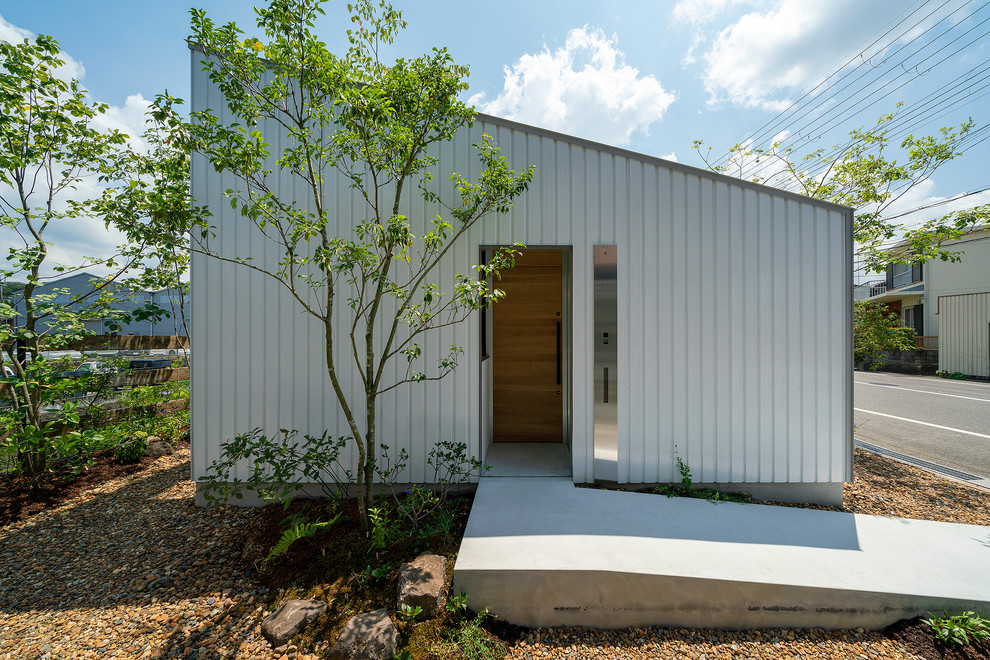 Пример оригинального дизайна: одноэтажный, серый частный загородный дом среднего размера в стиле модернизм с облицовкой из металла, односкатной крышей и металлической крышей