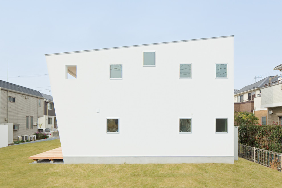 Cette photo montre une façade de maison blanche tendance avec un toit en appentis.