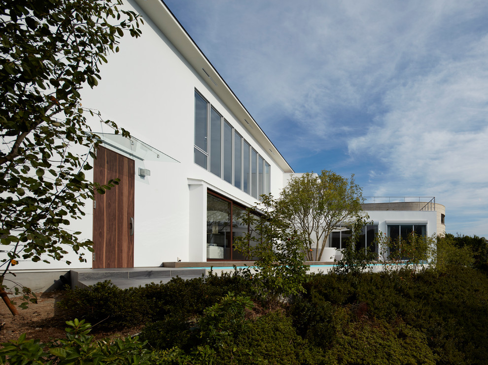 Foto della facciata di una casa grande bianca contemporanea a due piani con tetto piano