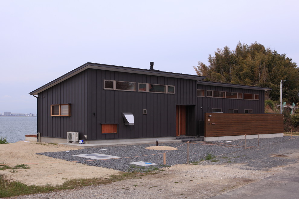 Photo of a black industrial bungalow detached house in Other with a lean-to roof and a metal roof.