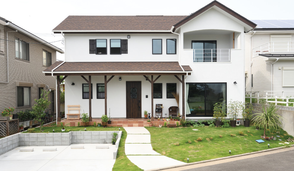 Aménagement d'une grande façade de maison blanche asiatique en stuc à un étage avec un toit à deux pans et un toit mixte.
