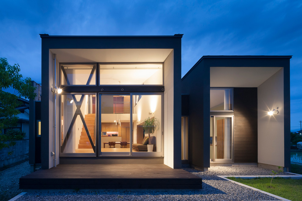 Réalisation d'une petite façade de maison noire minimaliste à niveaux décalés avec un revêtement mixte et un toit plat.
