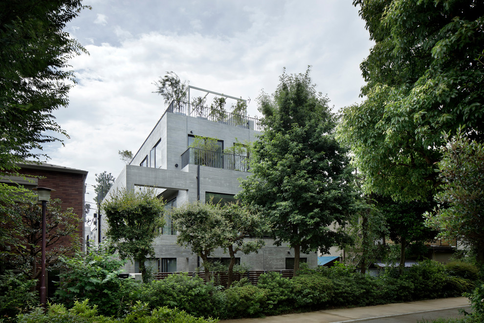 Diseño de fachada de casa gris minimalista grande de tres plantas con revestimiento de hormigón y tejado plano