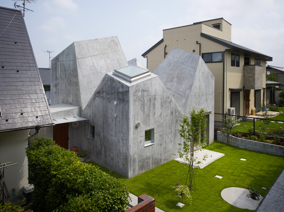Cette image montre une façade de maison grise design en béton.