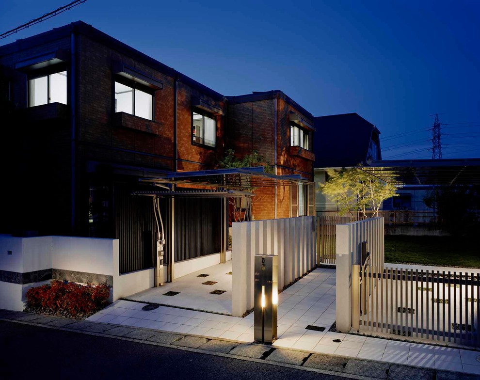 Cette photo montre une façade de maison marron moderne en brique à un étage avec un toit plat.