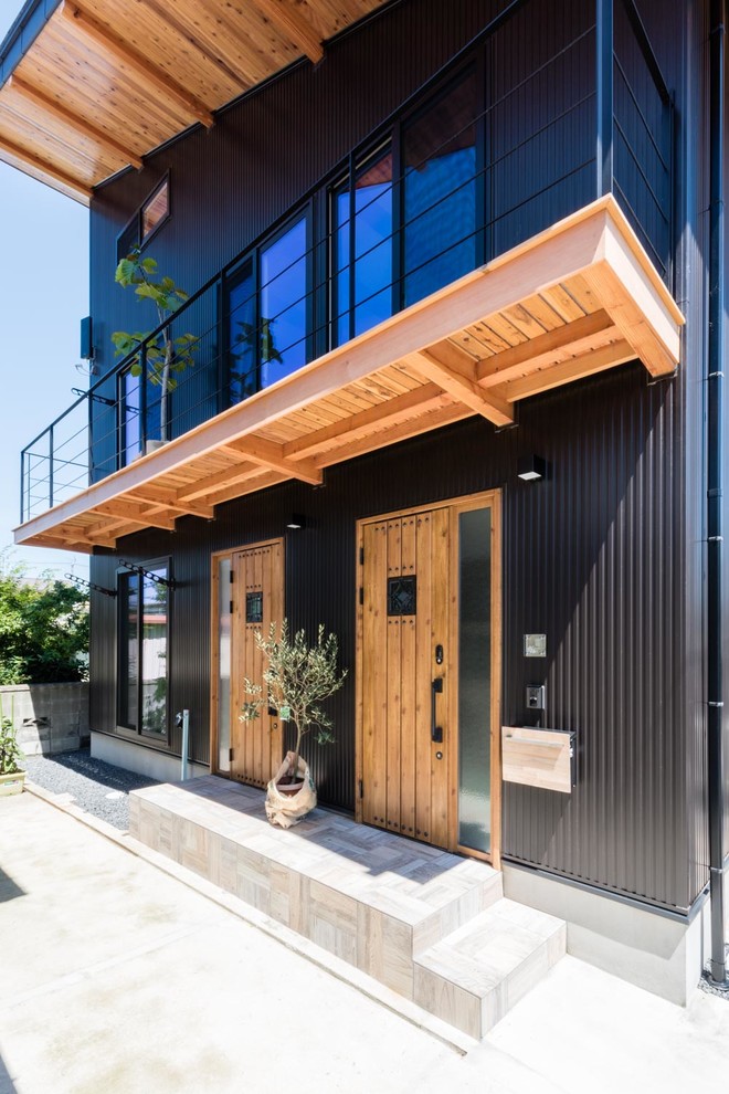 Идея дизайна: большой, двухэтажный, черный частный загородный дом в восточном стиле с комбинированной облицовкой, односкатной крышей и металлической крышей