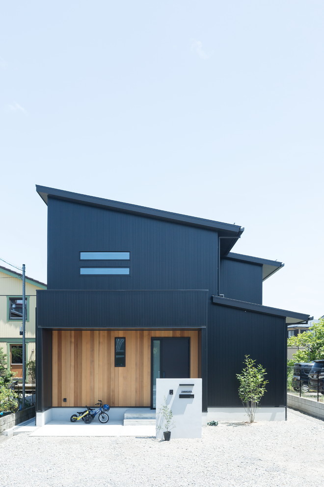 Inspiration för moderna svarta hus, med pulpettak, två våningar och blandad fasad