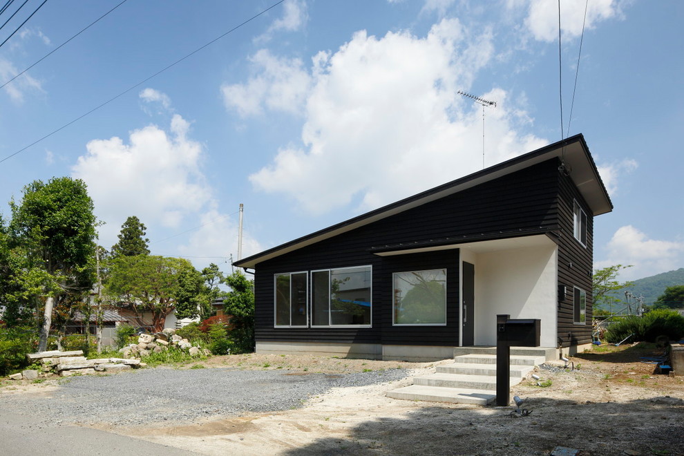 Asiatisches Haus mit schwarzer Fassadenfarbe und Pultdach in Sonstige