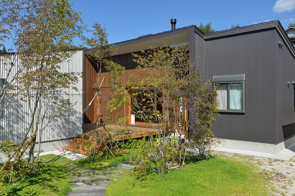 Foto de fachada gris de estilo de casa de campo pequeña de una planta con revestimiento de metal y tejado de un solo tendido