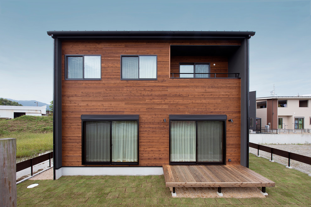 Brown contemporary house exterior in Other with a flat roof.