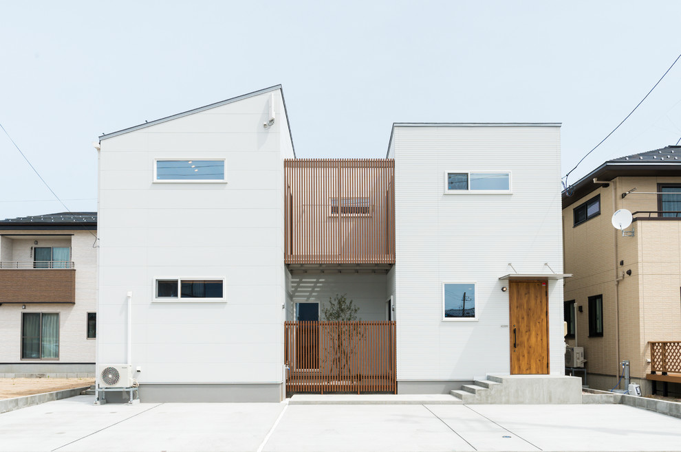 Стильный дизайн: двухэтажный, белый частный загородный дом в восточном стиле с комбинированной облицовкой и односкатной крышей - последний тренд