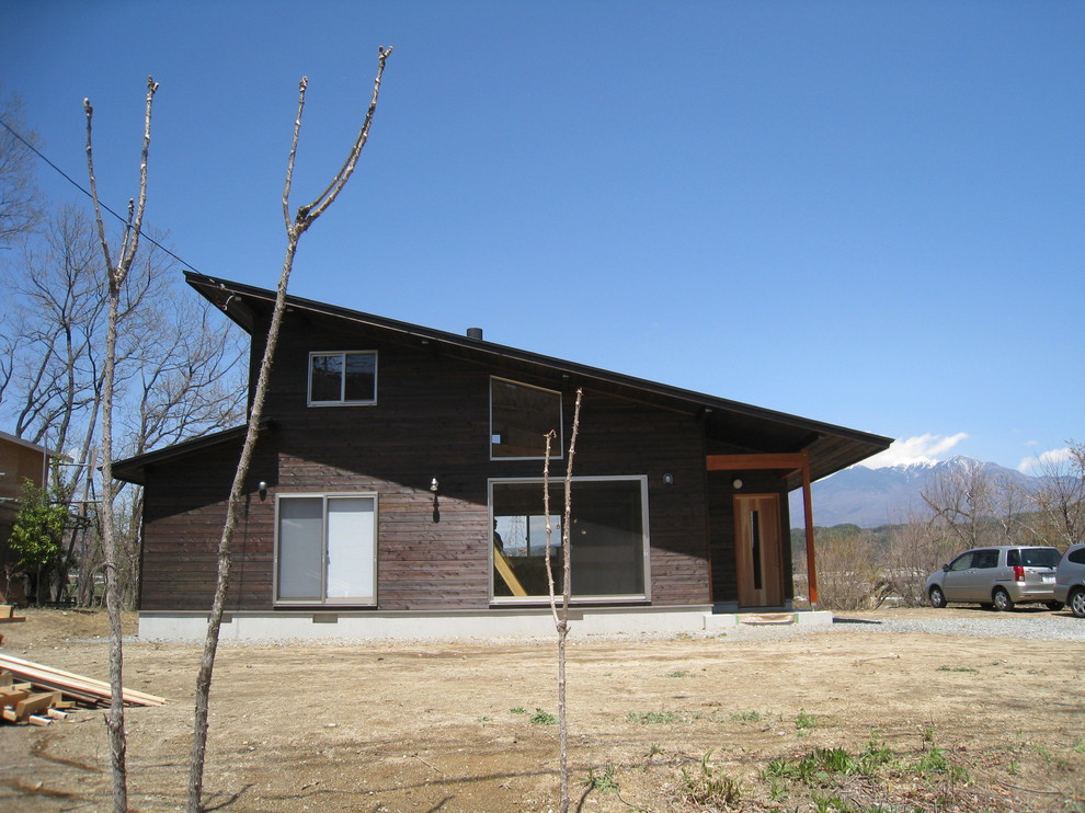 Kleines, Zweistöckiges Asiatisches Einfamilienhaus mit brauner Fassadenfarbe, Pultdach und Blechdach in Sonstige