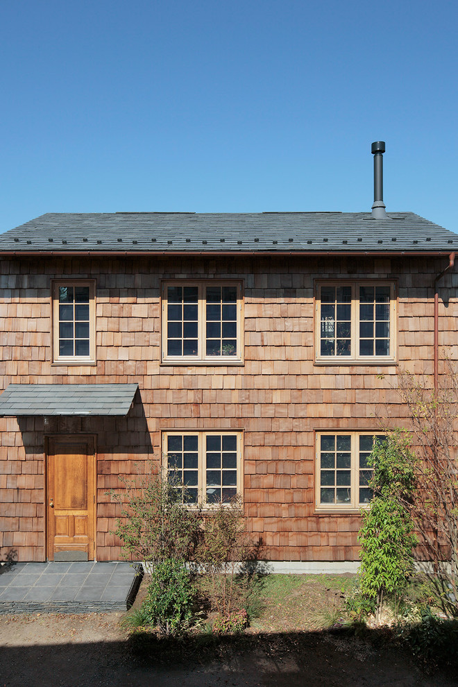 Idee per la facciata di una casa marrone country a due piani con rivestimento in legno e tetto a capanna